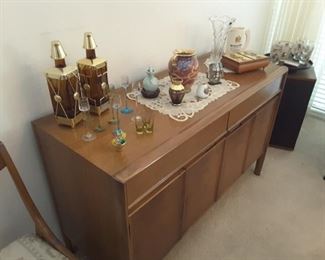 Sideboard Mid Century Drexel Heritage, 2 upper drawers, and 2 lower cabinets which have upper shelves. Lots of storage for dishes sets, glassware and linen. Unique collectibles on upper area.