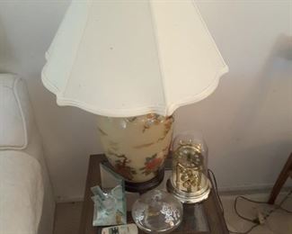 Asian Like Ceramic Table Lamp. Small square end table. Collectibles glass, small clock, silver plated dish and small collectibles below the end table.