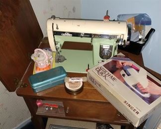 Empire sewing machine and cabinet with small chair. Sewing supplies and knick knacks for sewing related project.