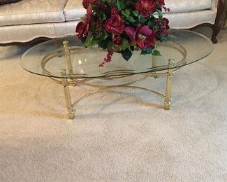 Glass top brass coffee table. One of the many very nice flower arrangements we are offering.