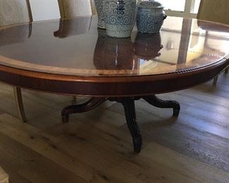 Gorgeous Henredon Natchez Collection dining table. Flame mahogany with lighter inlay band at perimeter. Brass ferrules at feet. 64” round. Expands to 87.5” long with leaf. 26.5” to bottom of apron. 2 scuffs and missing one brass ferrule. $1500.00
