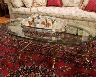 Italian oval brass and glass coffee table with an antique silverplate two handle tray and a porcelain teaset