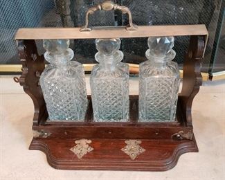 Antique Dorflinger & Sons New York tantalus. Dark oak 
and brass with three crystal bottles, circa 1880's