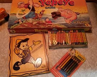 Popeye game, Pinocchio wooden puzzle, Daffy Duck crayolas and Sunset color pencils