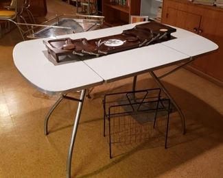 Drop leaf formica and chrome table with a black metal and brass magazine holder