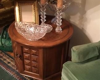Small commode table in hallway with more glass items