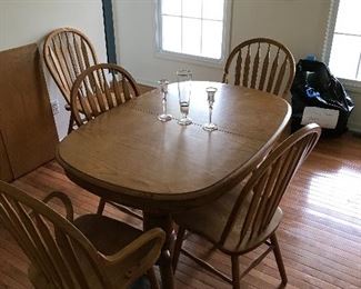 Golden oak dining room table with six matching chairs and two leaves