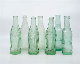 Lot 118. Seven vintage Coca-Cola bottles and Nu Grape glass bottles.
