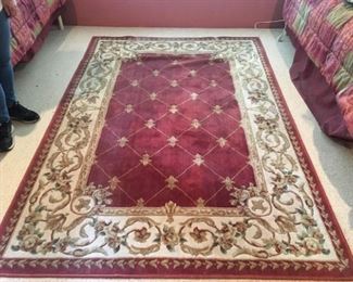  Large Rose Fleur De lis Rug. There are bumps and impressions where furniture was previously.