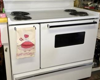•	Frigidaire electric stove/range/oven, white, Model No FEF450WFWC. 40-1/8” wide by 47.25” tall by approx. 26” deep. Small auxiliary oven on the left side (16”Hx19.5”Dx9-9/16”W).  Main oven (15-7/8”Hx18-1/8”Dx22-5/8”W). 4 burners