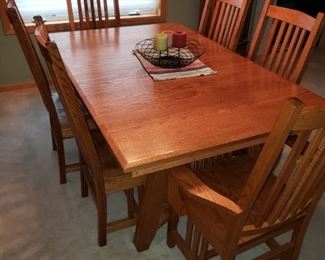 Mission style dining room table and chairs with leaves tucked underneath