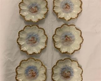 SET OF 6 LIMOGES TRANSFER AND GILT DECORATED PORCELAIN CABINET PLATES, Circa 1880-1900. Centered by pairs of playful amores, the rims molded with coquillage and picked out gilt