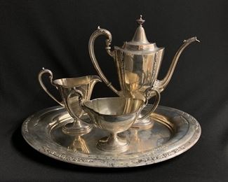 AMERICAN EDWARDIAN STERLING SILVER THREE PIECE DEMITASSE SERVICE.  Designed in the late 18th c.  neo-classic style.  The service comprised of a pedestal-based demitasse coffee pot  with hinged cover and tendril scroll handle; a double handled sugar bowl and a spouted cream pitcher and oval silver tray 