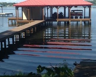 A roomy boathouse is another "plus" for this lake home. (The barge & those jet skis go with the sale of the house.)