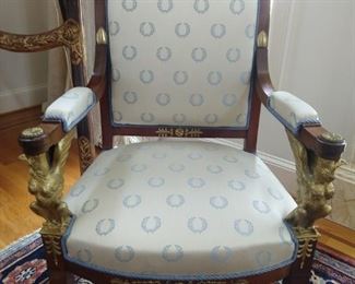 This period mahogany chair has arms formed with gryphon crests and is covered in cream/Wedgwood blue laurel wreath fabric; from the home of interior designer Franya Waide. 