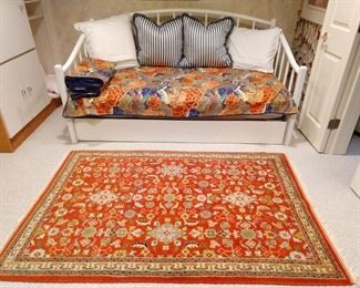 Dayglow orange Persian design rug (4 x 6) wooden daybed with happy pillows.