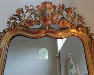 Top detail of the French gilt wood wall mirror. 