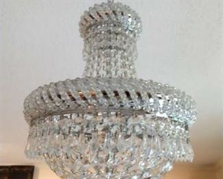One of a pair of crystal crown chandeliers.
