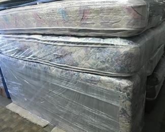 Two king size mattresses with box springs in like-new condition wrapped in plastic