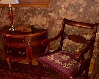 one of two mahogany side chairs with needle point seats, one arm chair and one without arms