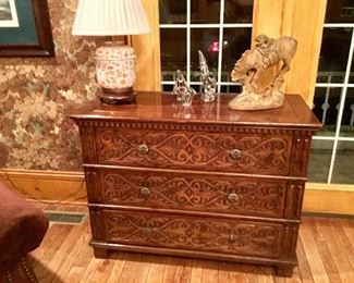 Antique English oak three drawer  chest with pressed front design. Chinese lamp, crystal figures and cowboy wrangler statue. 