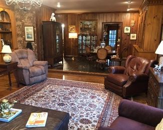 Family room view with Persian rug, recliners, table, chairs, etc