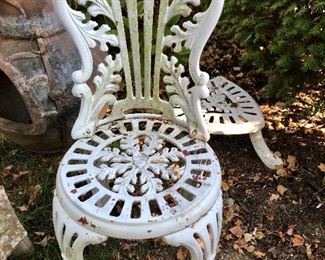 Victorian cast iron chair and plant stand in the background. 