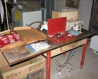 sewing machine mounted on old table, red box is full of buttons, (there are lots more buttons)
