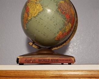 Reploge globe on stand holding world atlas