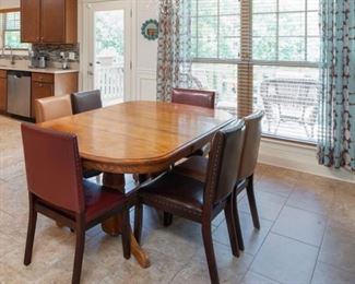 Closer look at the dining room Pedestal Table with Six multi color Leather Parsons Chairs. All priced to sell first day.