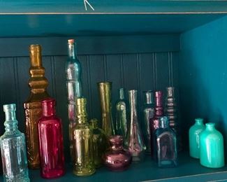Assortment of Colorful Glass Bottles ranging in sizes and color.