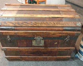 This old trunk has wheels and leather handles