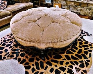 large round tufted ottoman and animal print cowhide rug