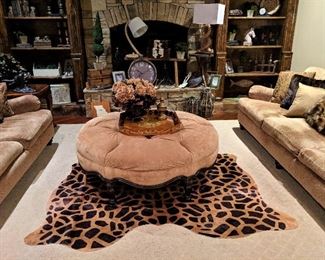 large round tufted ottoman and animal print cowhide rug