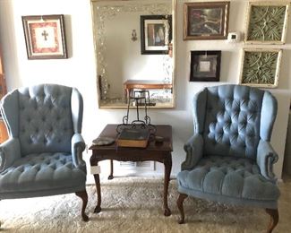 Two wingback chairs, table, large mirror, wall Decorations