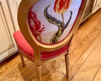 Each upholstered chair has a colorful flower on the back.