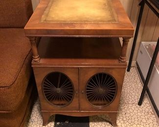Weiman Mahogany & Leather Top End Tables, Solid wood construction, tooled leather tops, 2 swing cabinet doors with metal sunburst grills, tops raised on column supports, finished backs, great American craftsmanship. Early to Mid 1900s, American
27" H x 18" W x 22.5" D