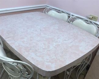 Pink Laminate Vintage Kitchen table with one extension wrought iron heavy legs and chairs with white vinyl cushions barely used.