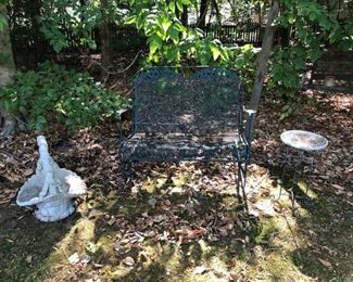 Green wrought iron glider. Outdoor planter