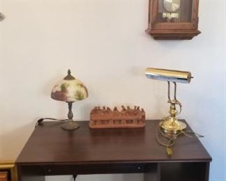 desk with lamps and wall clock