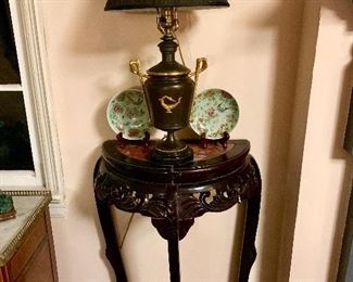 One of a pair of Chinese rosewood and granite hall tables both holding French oil lamps, this table also holds a non matching pair of Chinese celadon plates 