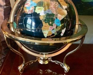 A large stone globe containing many semi  precious stones  