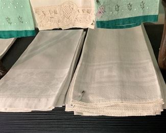 Collections of white linen hand towels each set containing between four and eight towels