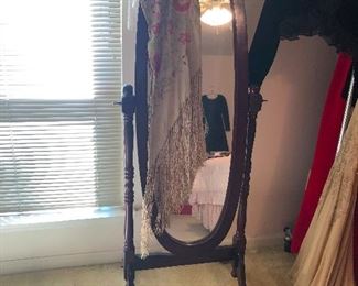 Standing mirror depicting invisible woman wearing a black dress