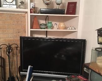 flat screen TV, mantel clock, Weller vase, fireplace set
