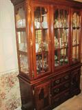 Cherry lighted china cabinet with 3 shelves and glass on the sides