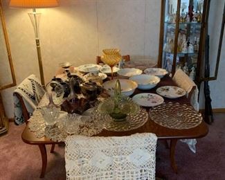 dining room table..curio..bell collection..antique dishes including china sets..tablecloths