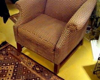 One of a pair custom upholstered chairs, Oriental rug.