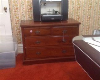 Vintage turntable with fold out speakers on low chest of drawers