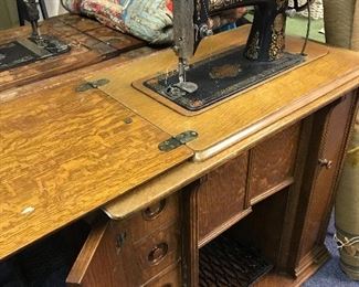 Antique Singer sewing machine in a pristine oak parlor cabinet.